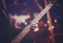 Artiest toert door Europa met basgitaar gebouwd van Temu-koopjes Close-up weergave van gitarist hand-bass gitaar